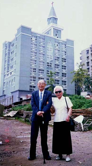 杨毓英牧师和杨程继美师母在华差资助湖北中南 神学院兴建8楼壮观校舍前留影.jpg 杨毓英牧师和杨程继美师母在华差资助湖北中南 神学院兴建8楼壮观校舍前留影.jpg